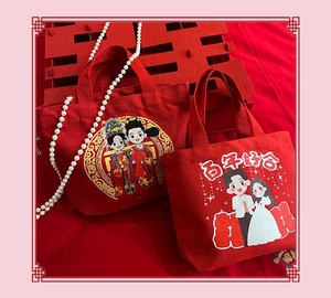 Detailed view of red wedding canvas gift bags with cartoon couples and festive decor