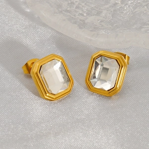 Boucles d'oreilles carrées dorées avec zircon radiant sur fond en soie luxueuse
