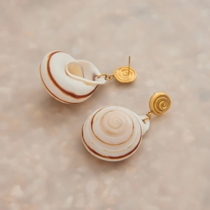 Detailed macro view of natural brown conch shell earrings with gold spiral stud design