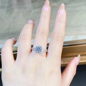 Detailed view of 1-carat round moissanite halo engagement ring on model finger