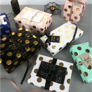 Modern gift wrapping paper with gold dots and matching ribbons in assorted colors