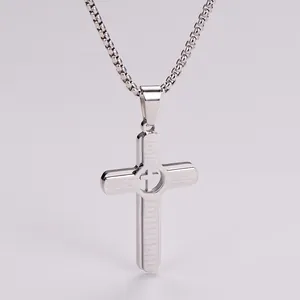 Macro detail of silver stainless steel cross pendant with engraved English Lord's Prayer