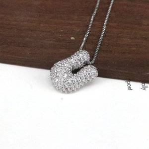 Makroaufnahme der silbernen Kette mit dem mit Zirkonia besetzten Buchstaben U