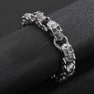 Détail d'un bracelet tête de mort punk avec texture argentée sur un support noir