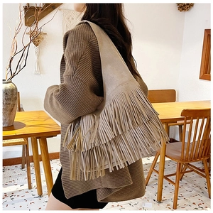 Bohemian large capacity fringe shoulder bag in beige suede material worn by model