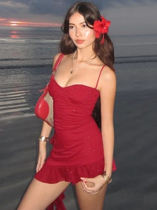 Sparkly red sleeveless mini dress with ruffle hem shown on a sunset beach setting