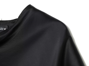 Close-up of black satin cape top showing smooth fabric texture and refined shoulder stitching