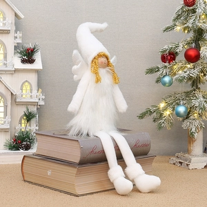 Détail d'une poupée d'ange de Noël en peluche blanche aux longues jambes sur des livres