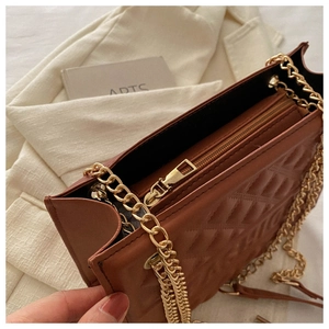 Detail view of large capacity embossed chain bag with gold zipper and inner compartment