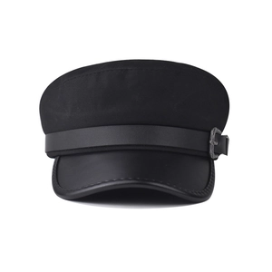 Detailed close-up of a black baker boy hat featuring a silver vintage metal buckle