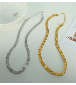 Detail of flat woven mesh necklaces in gold and silver with lobster clasp and shell decor