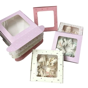 Elegant window display gift boxes with assorted floral and polka dot scrunchies inside