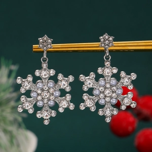 Detail of snowflake earrings with silver base, blue faux pearls, and sparkling rhinestones