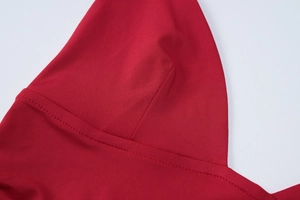 Detail of red V-neck crop top showing premium stitching and smooth elastic fabric texture