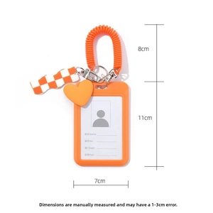 Detail view of orange checkerboard card holder with heart charm and retractable lanyard