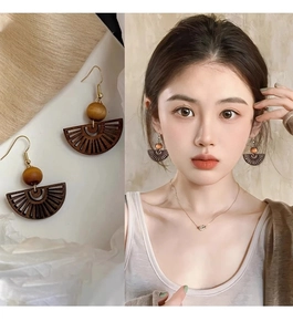 Detail of wooden fan-shaped hollow drop earrings with beads shown on model and still life