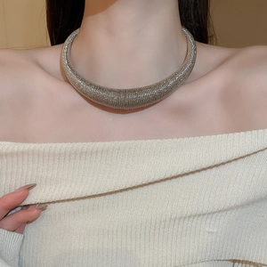 Detailed view of silver wide-band choker with intricate woven metal texture on a neck