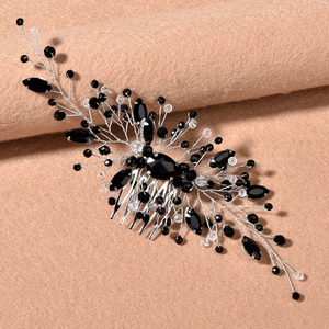 Close-up of bridal hair comb with emerald crystals and silver wire branch detailing