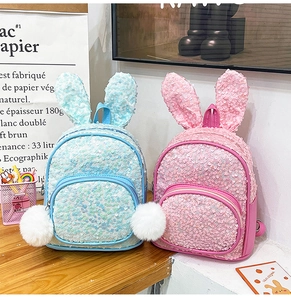 Detail of cute rabbit ears and fluffy pompom on sequined children backpack