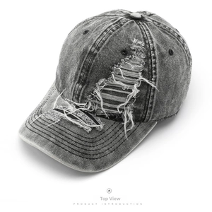 Top view of a dark grey washed denim baseball cap with vintage distressed ripped details