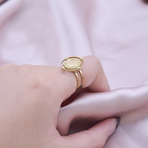 Detail view of gold oval signet ring with beaded edges and double-band minimalist design