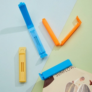 Close-up of plastic sealing clips in blue and orange on colorful geometric backgrounds