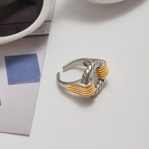 Détail de la bague ouverte torsadée bicolore en or 18 carats et acier inoxydable poli