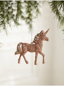 Close-up of a glittery rose gold unicorn Christmas ornament hanging on a pine tree branch