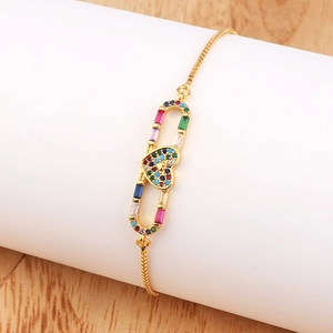 Detail of adjustable gold bracelet with heart-shaped colorful cubic zirconia and oval link