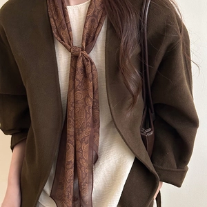 Elegant paisley silk scarf necklace paired with a brown wool coat and cream top