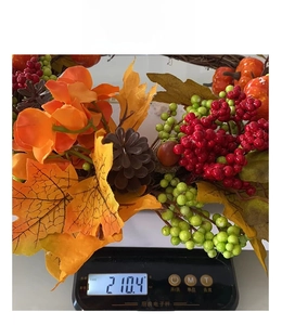 Detailed weight measurement of autumn wreath with maple leaves and pumpkins on scale