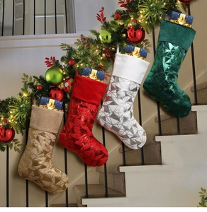 Close-up of four glitter Christmas stockings with geometric patterns on a staircase