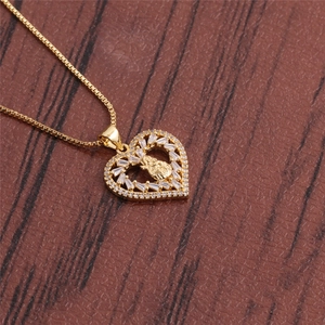 Golden heart lock necklace with pavé zirconia crystals and bee pendant on wood