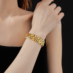 Detail of vintage gold leopard print square link bracelet on a woman wrist