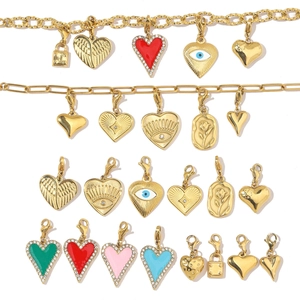 Detailed flat lay of diverse enamel heart and eye charms in gold stainless steel