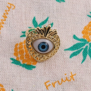 Macro detail of gold plated heart ring featuring a blue zircon Evil Eye centerpiece