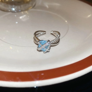 Close-up of silver-tone cross ring with light blue zircon and sparkling accents