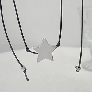 Minimalist silver star pendant necklace with adjustable black cord and metallic accents