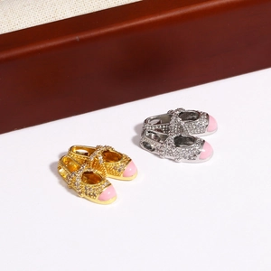 Detailed macro view of ballet slipper pendants with inlaid zircons and pink enamel