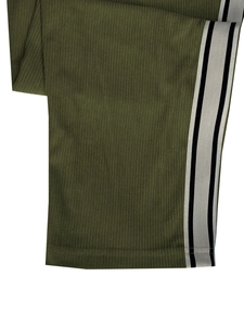 Gros plan détaillé du pantalon en velours côtelé vert olive avec bandes latérales
