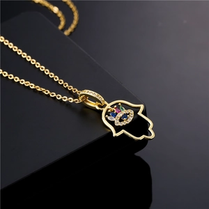 Detail of 18K gold plated Hamsa hand pendant with blue evil eye and colorful zircon stones