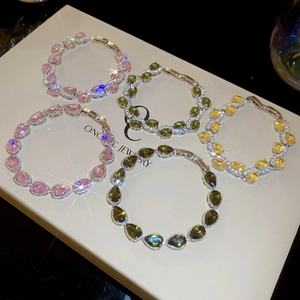 Detailed view of pear-cut colorful zircon bracelets in pink, green and yellow with claw setting