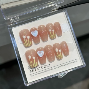 Detailed macro of handmade press-on nails with 3D tulip floral patterns and glitter hearts