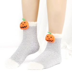 Detail von weichen grauen Plüschsocken mit orangem Kürbis Dekor für den Winterkomfort