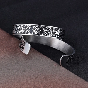 Vintage stainless steel Viking cuff bracelet with intricate Celtic knot patterns on a dark base