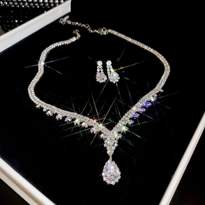 Detailed view of silver teardrop pendant necklace and earring set in a velvet box