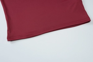 Detailed close-up of dark red knitted top hem featuring precise double-needle stitching