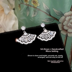 Detail of fan-shaped drop earrings with micro-set zircons on black display stand