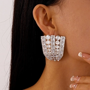 Macro shot of silver fan-shaped earrings with micro-paved zircons on female model