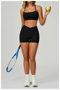 Detail of cross-high waist fitness shorts and elastic sports bra in black technical fabric